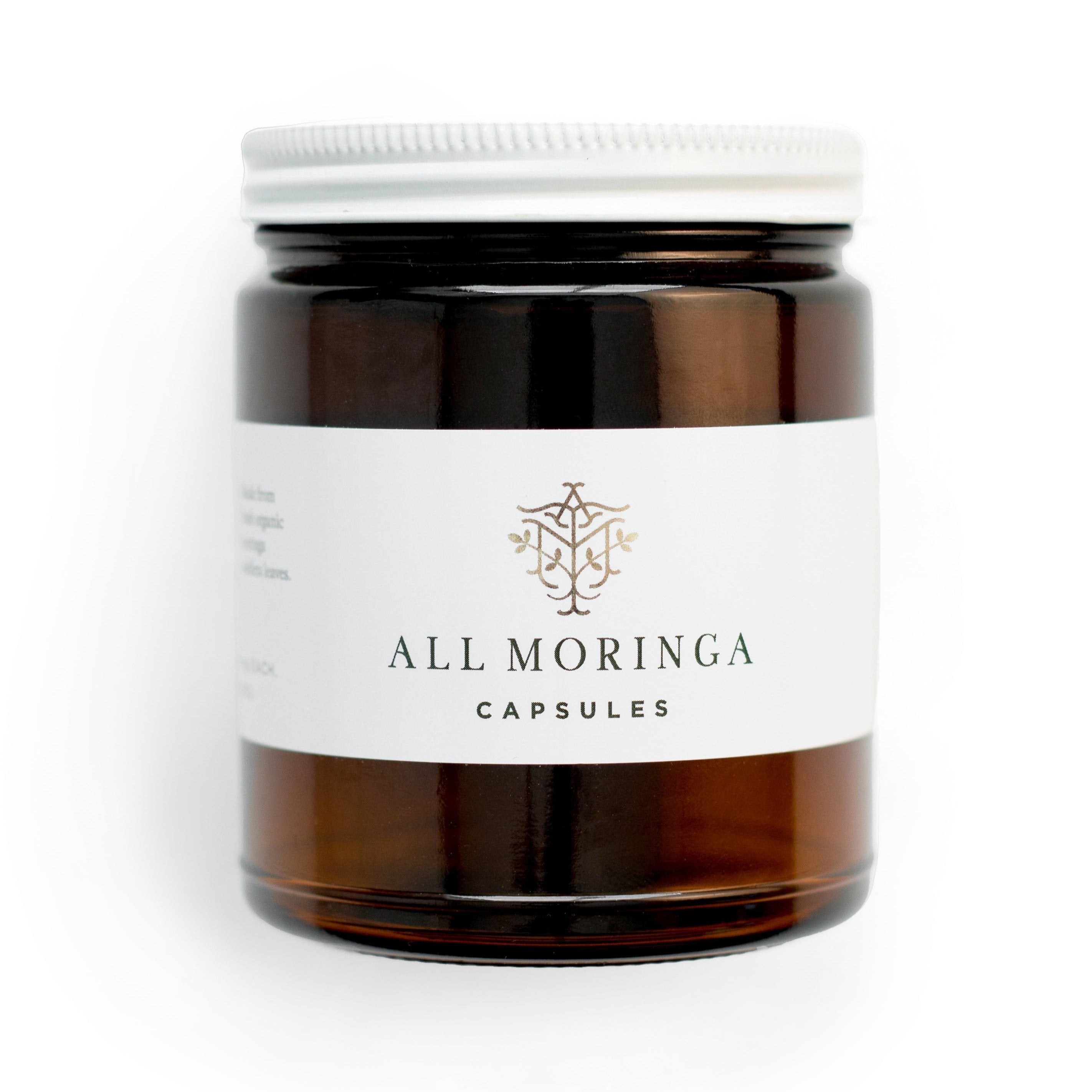 Superfood organic moringa leaves capsules in a glass jar and a metal cup with refillable pouch