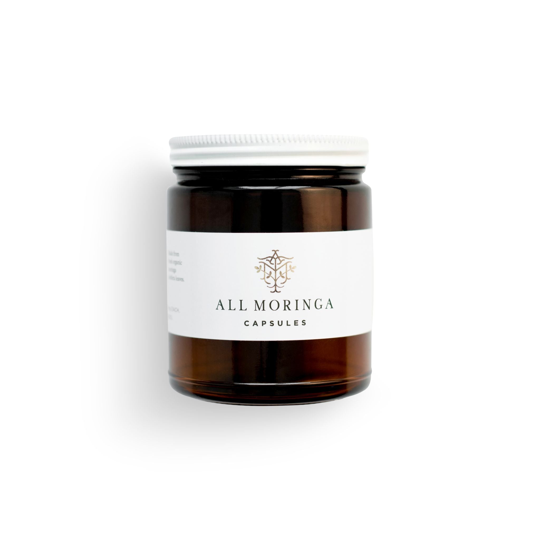 Superfood organic moringa leaves capsules in a glass jar and a metal cup