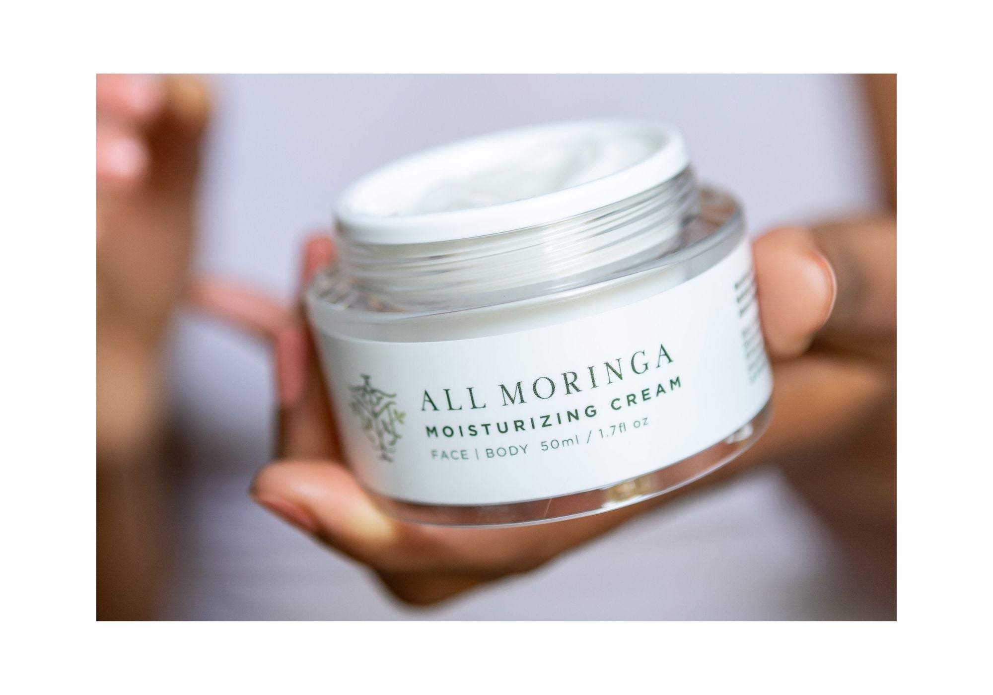hand holding an all Natural Moringa face cream for moisturizing and hydrating and nourishing