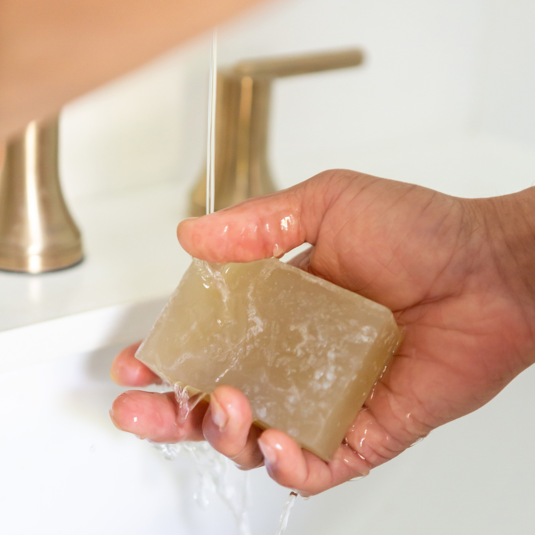 natural moringa soap bar with hand under water